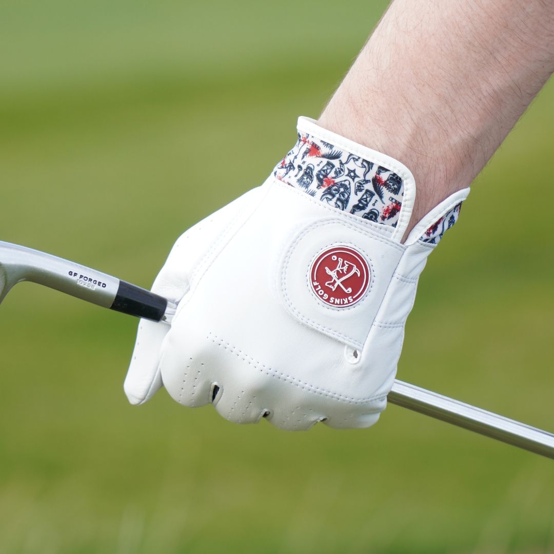 White golf glove with a red logo on a blurred green background