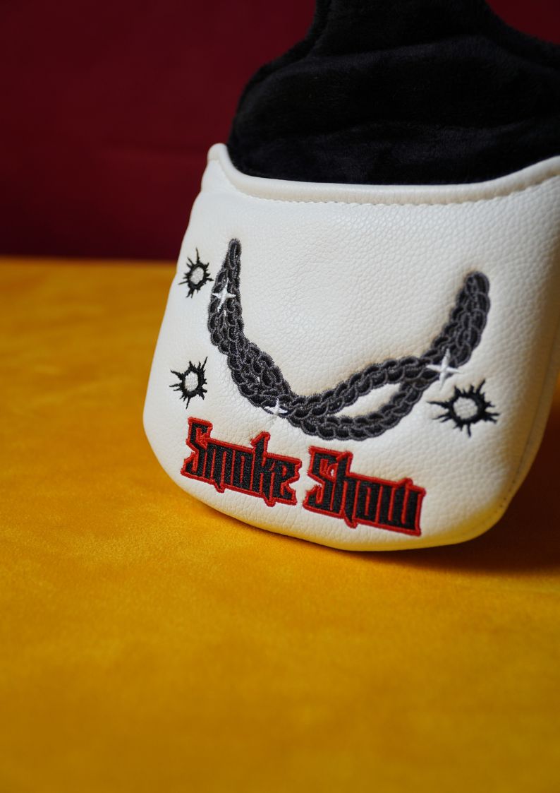 White golf headcover with a chain design and 'Smoke Show' text on a yellow surface.