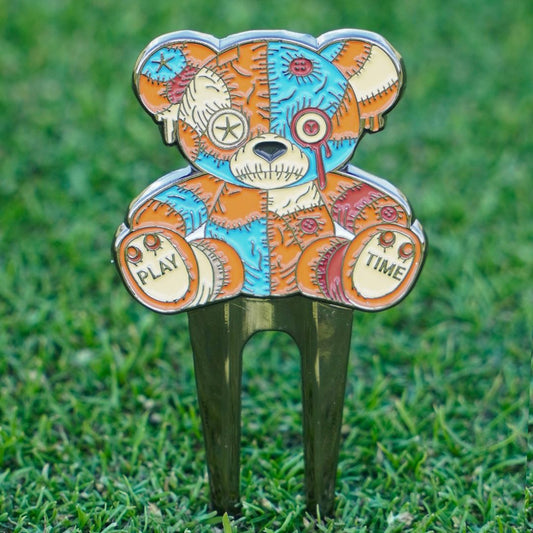 Colorful voodoo bear-shaped pitch mark repairer on grass