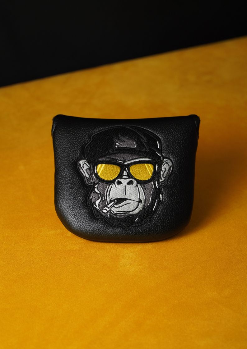 Black leather mallet headcover with a monkey design wearing sunglasses on a yellow background