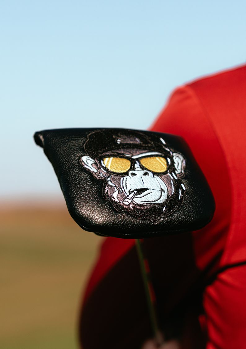 Golf club head cover with gorilla design and sunglasses on a blurred background