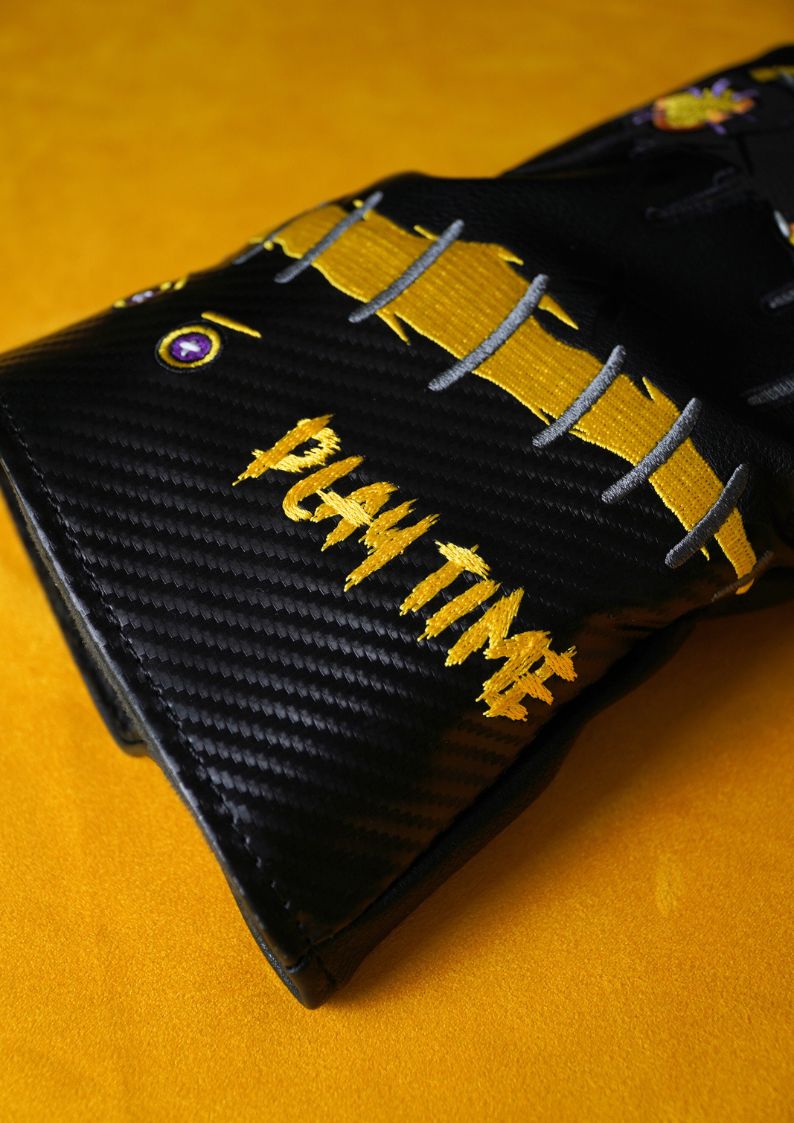 Black golf headcover for driver on yellow background