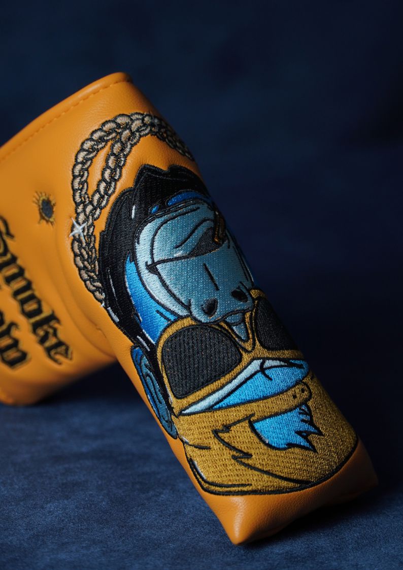 Leather blade headcover with blue embroidered design on a dark background