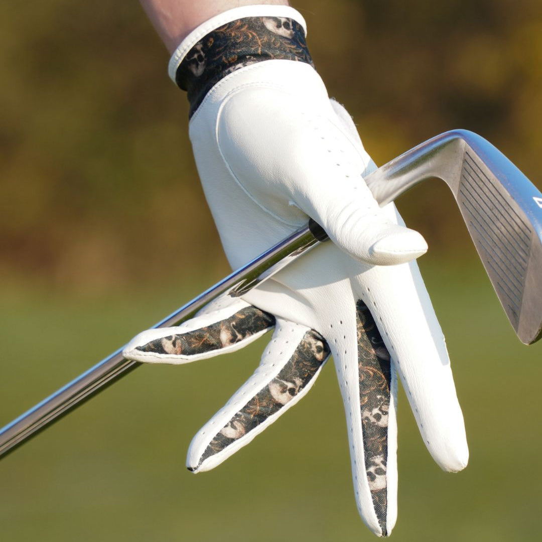 Golf club with a gloved hand on a blurred green background