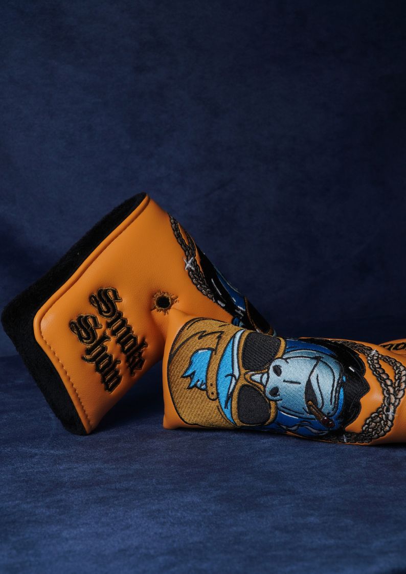 Two golf club covers with decorative designs on a dark blue background