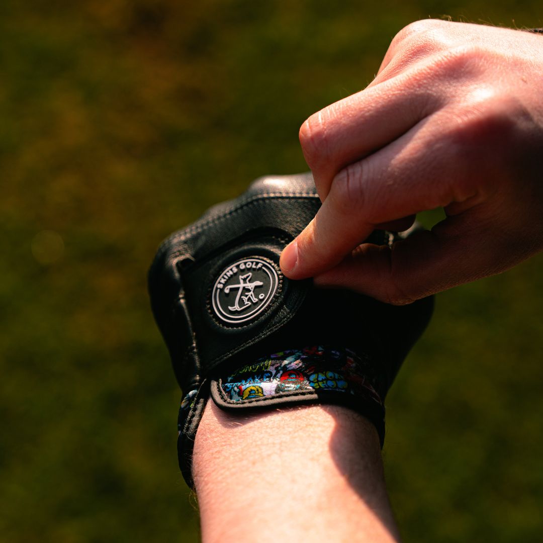 putting on black golf glove