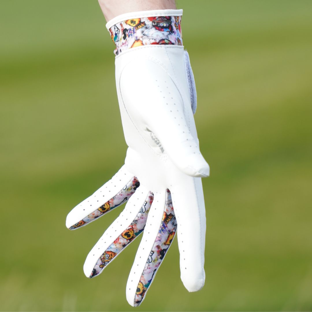 White golf glove with colorful pattern on a blurred green background