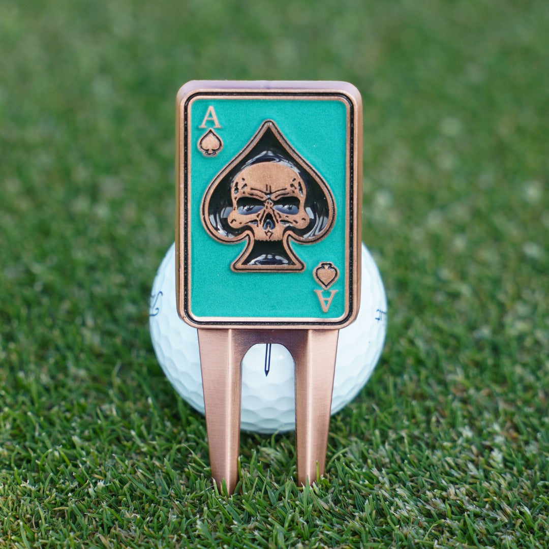 Golf ball with a card-themed divot tool on grass