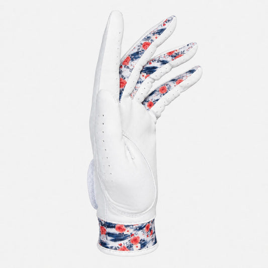 A white leather golf glove with a red and navy blue floral pattern on the back of the hand and wrist strap, shown against a light gray background.