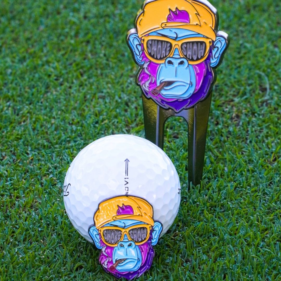 Golf ball marker and divot tool with gorilla design on grass