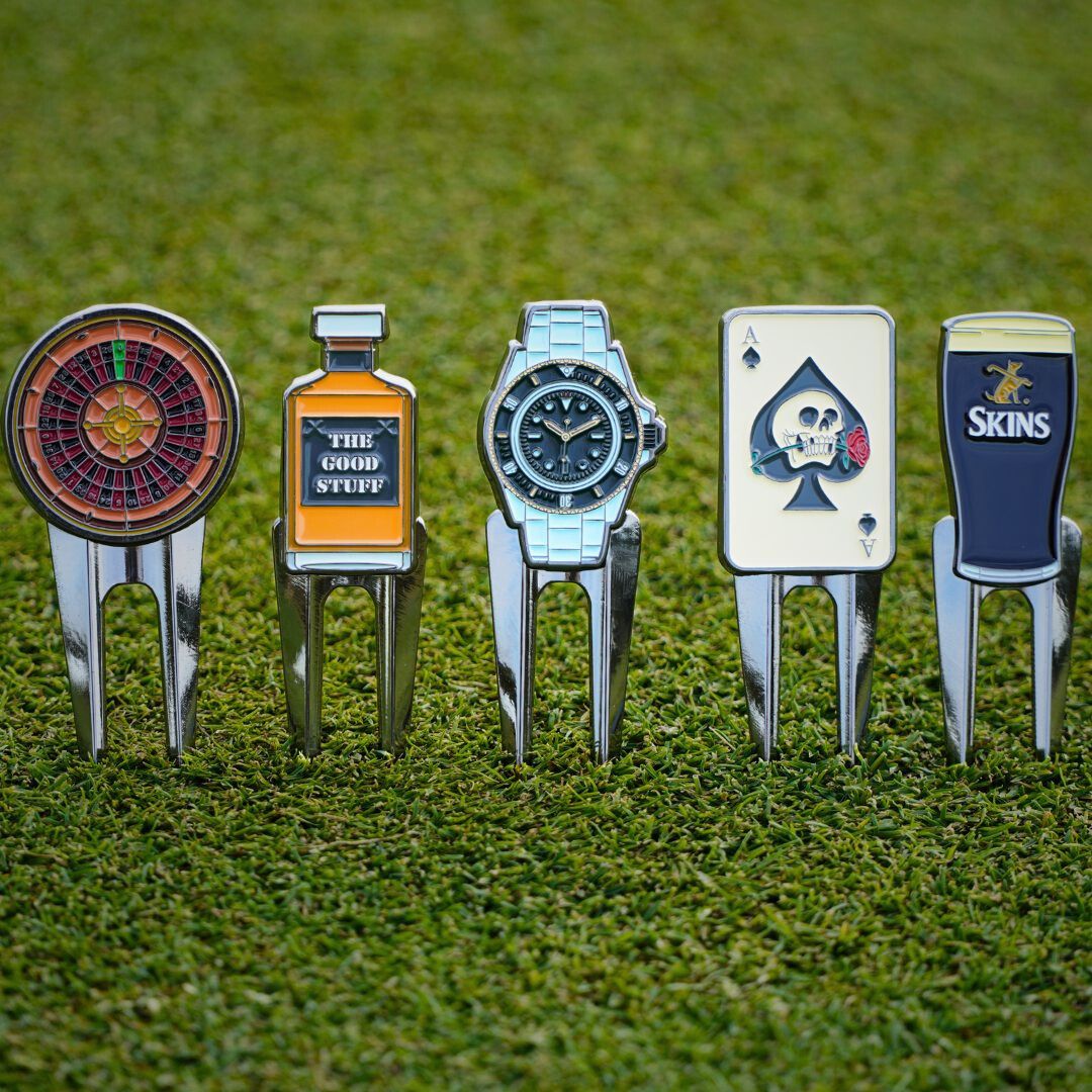 Set of golf divot tools with various designs on a grass background