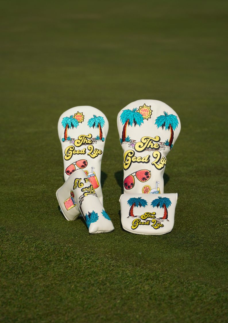 Two golf club head covers with 'The Good Life' design on a green background