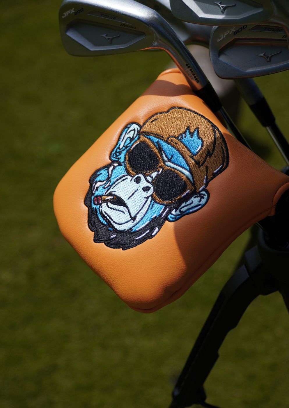 Golf club head cover with a gorilla design on a grass background