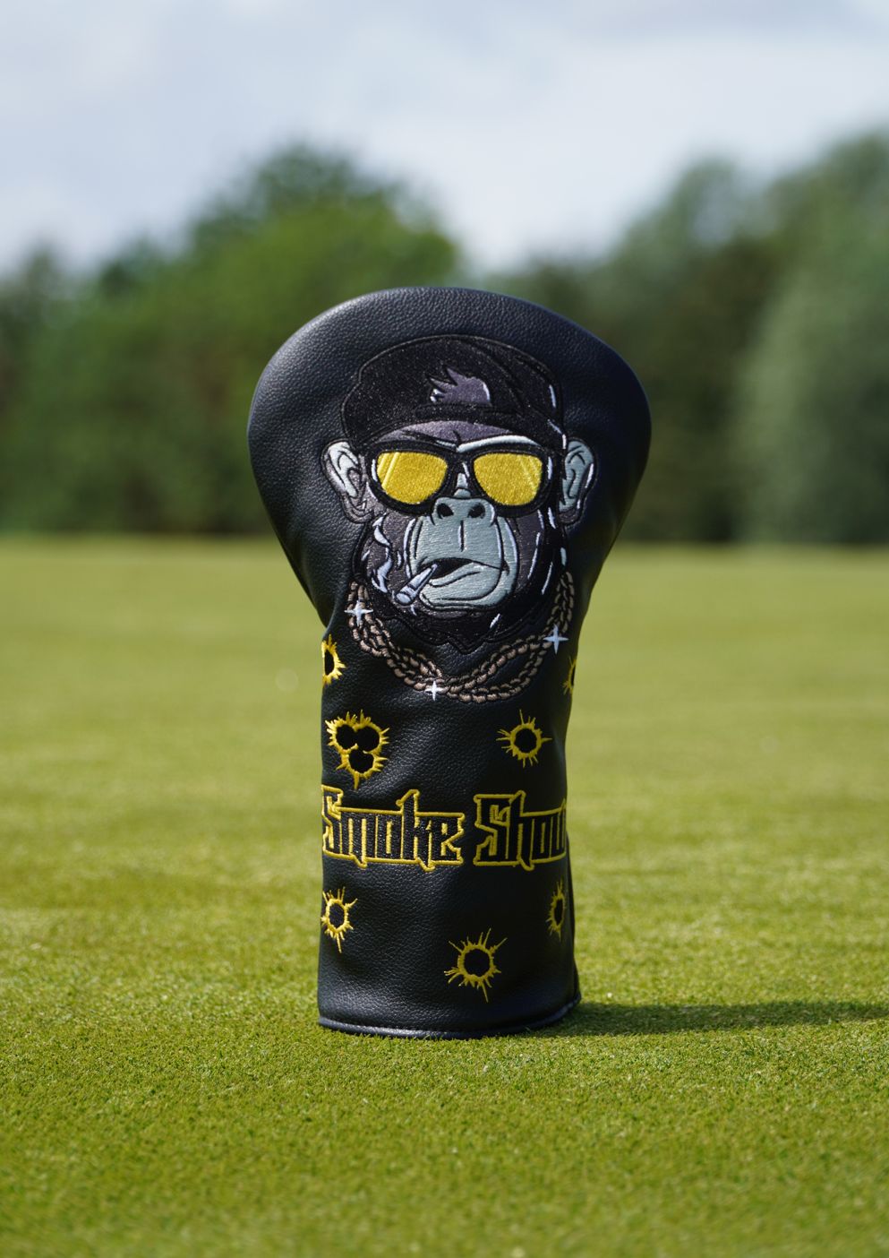 Golf club head cover with monkey design and 'Smoke Show' text on a grassy background