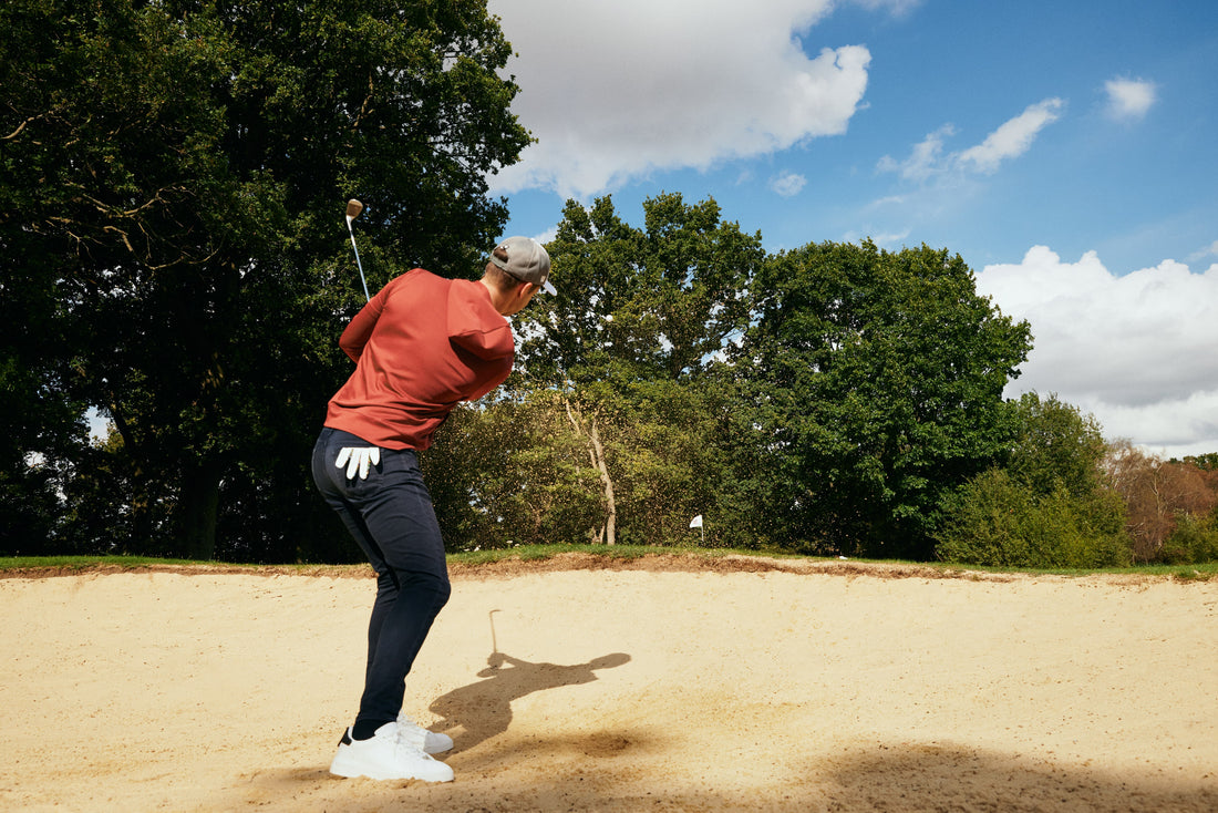 Golfer wearing golf hoodie hitting golf shot