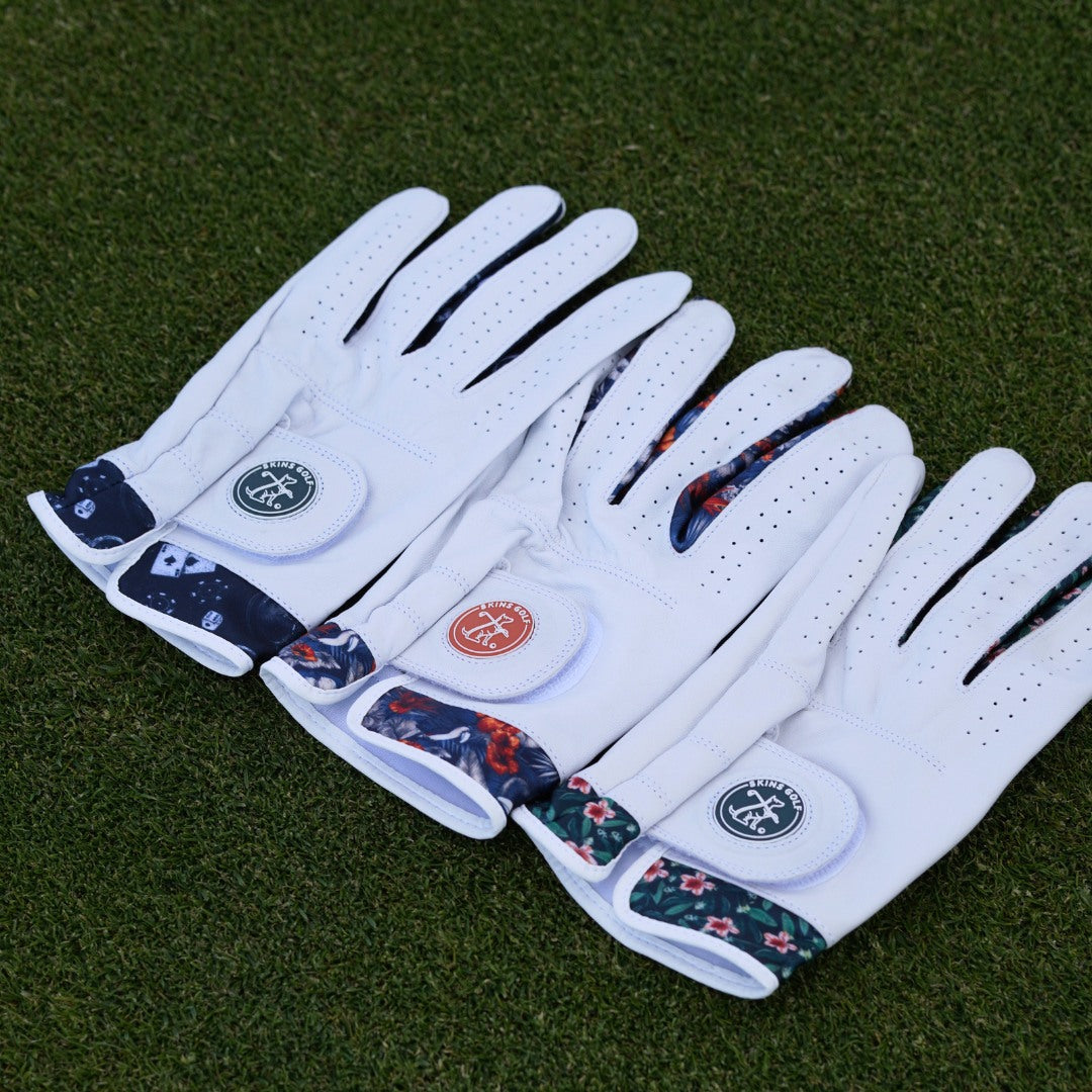 3 unique leather golf gloves on a green