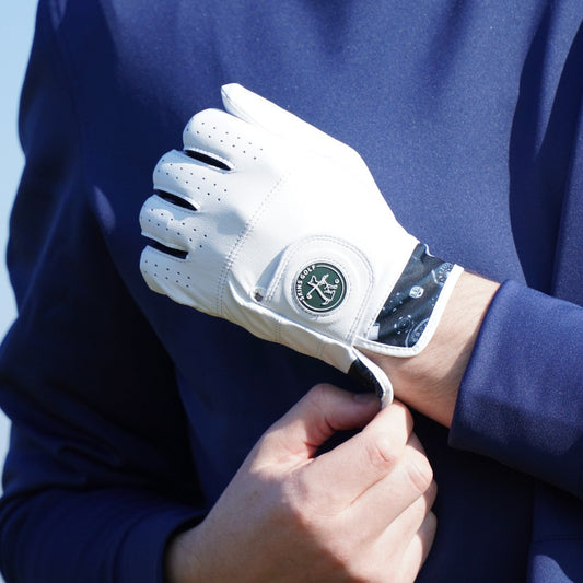 Golfer putting on white leather golf glove
