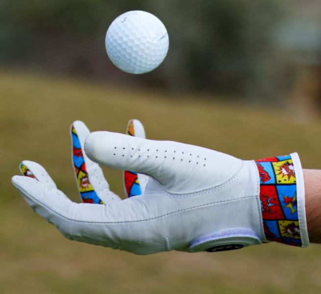 Golfer throwing up ball with colourful golf glove