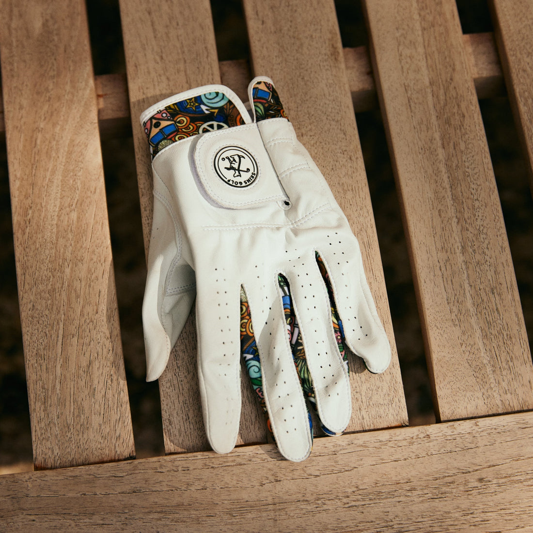 Cool golf glove on a wooden bench