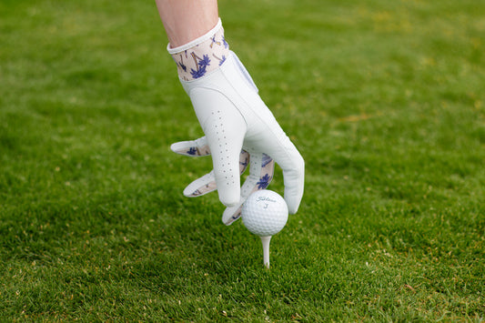 Cool golf glove with palm tree design teeing up golf ball