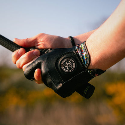 black leather golf glove holding a club