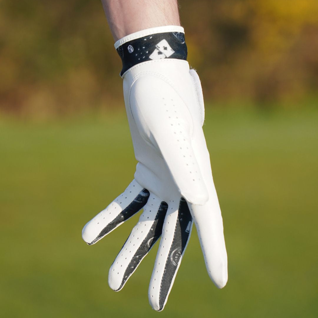 White golf glove with black accents on a blurred green background