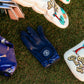 Golf glove and clubs on grass with a visible brand logo