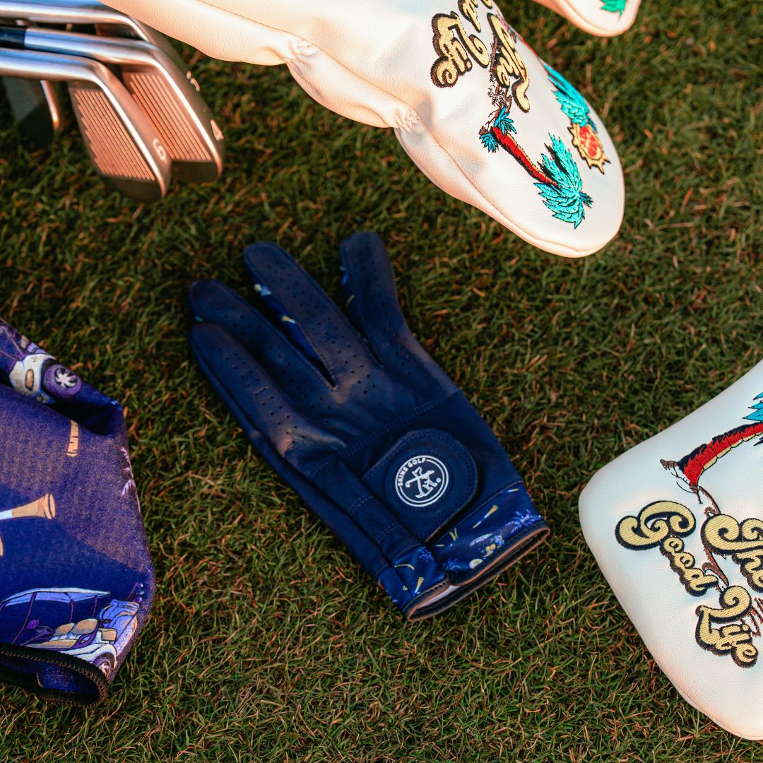 Golf glove and clubs on grass with a visible brand logo