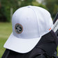 White golf trucker cap on golf clubs