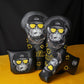 Four golf club headcovers with monkey designs and yellow sunglasses on a black and orange background