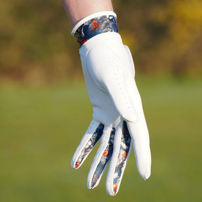 White golf glove with colorful pattern on a blurred green background