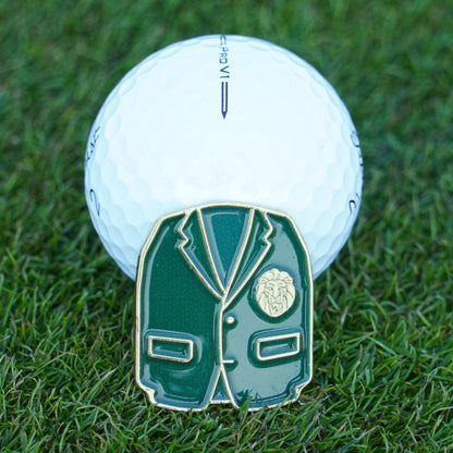 Golf ball with a green blazer ball marker on grass