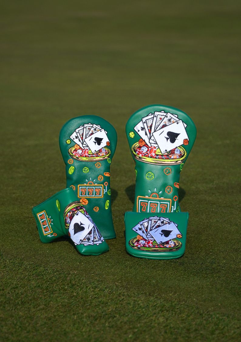 Two green golf club head covers with poker-themed designs on a green background