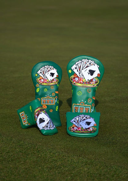 Two green golf club head covers with poker-themed designs on a green background