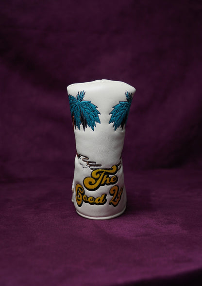 White golf head cover with blue palm tree designs and 'The Good Life' text on a purple background