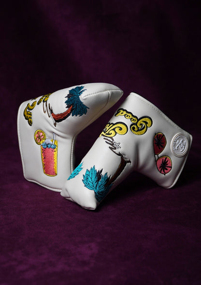 Decorative golf club head cover with colorful designs on a purple background