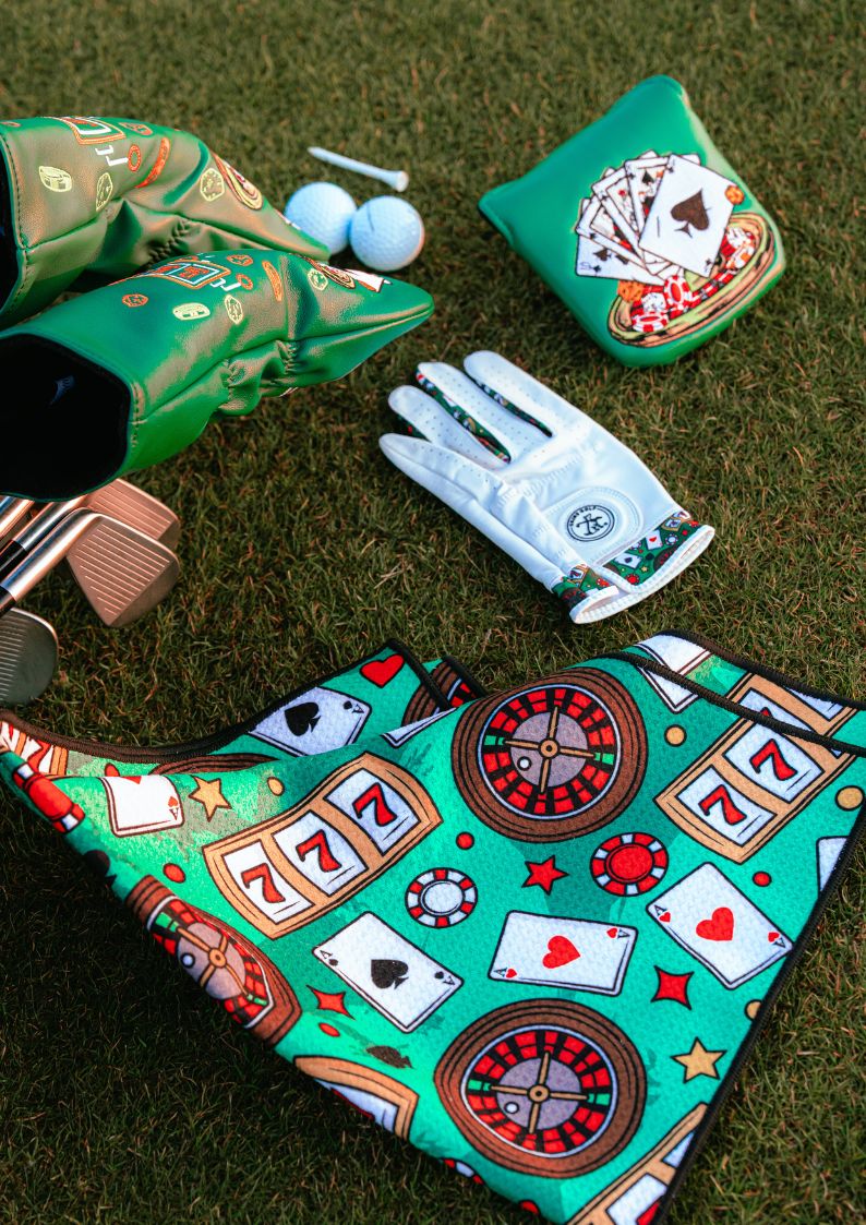 Casino-themed golf bag, gloves, and accessories on grass