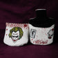 Two white golf headcovers with graphic designs on a dark purple background