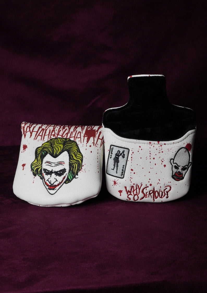 Two white golf headcovers with graphic designs on a dark purple background