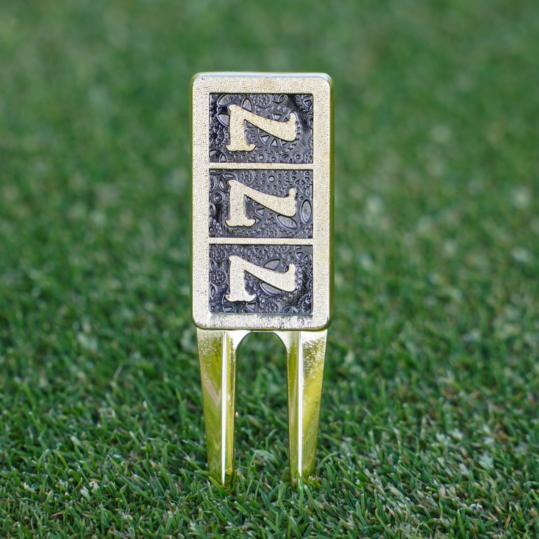 777 golf divot tool with a gold finish