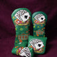 Decorative green headcovers with playing card designs on a purple background