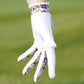 White golf glove with colorful pattern on a blurred green background