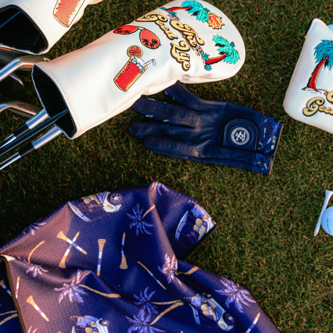 Golf club heads with decorative covers on a grassy background