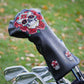 Golf club head cover with skull and rose design on a grass background