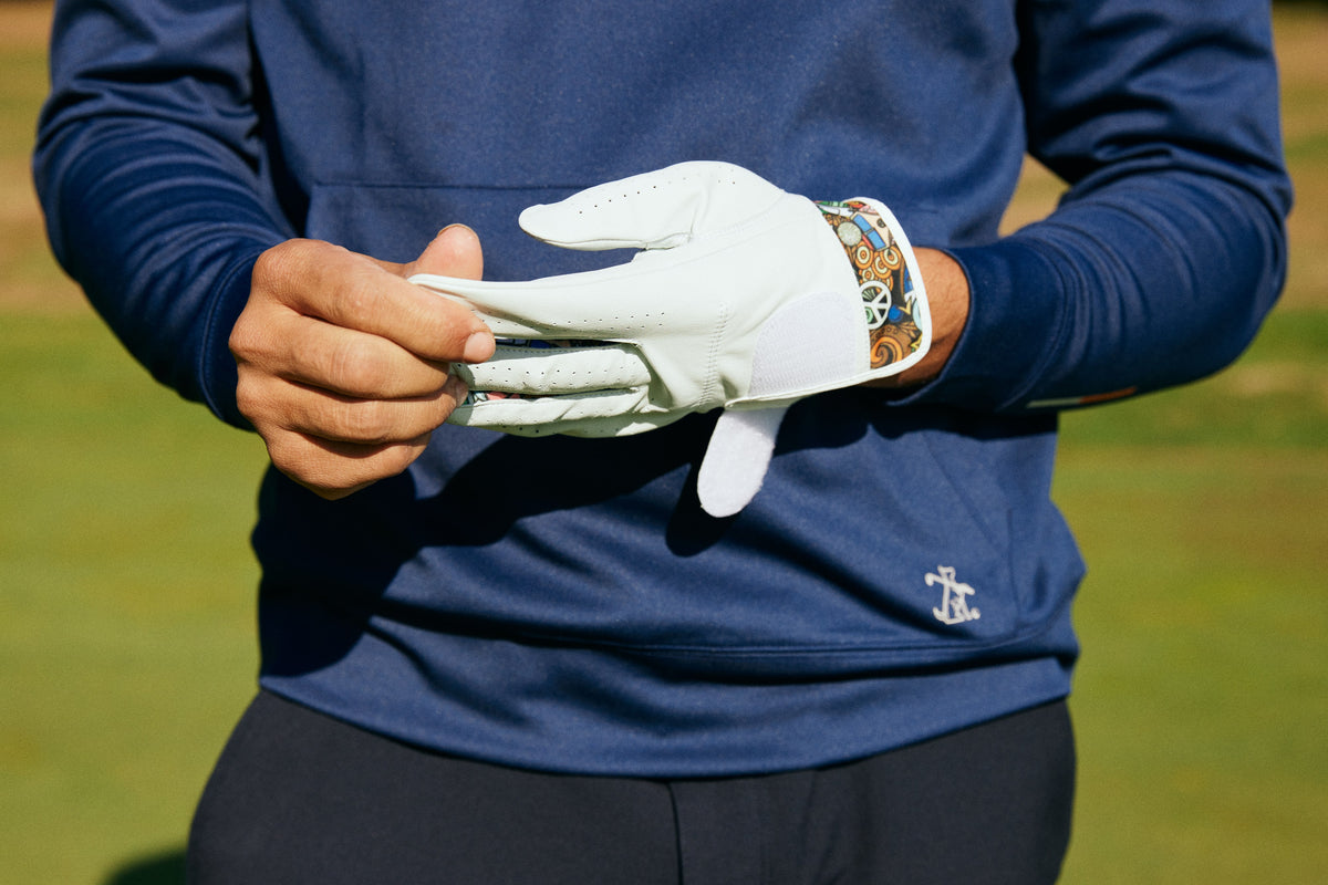 Golfer pulling on a Skins Golf cabretta leather glove