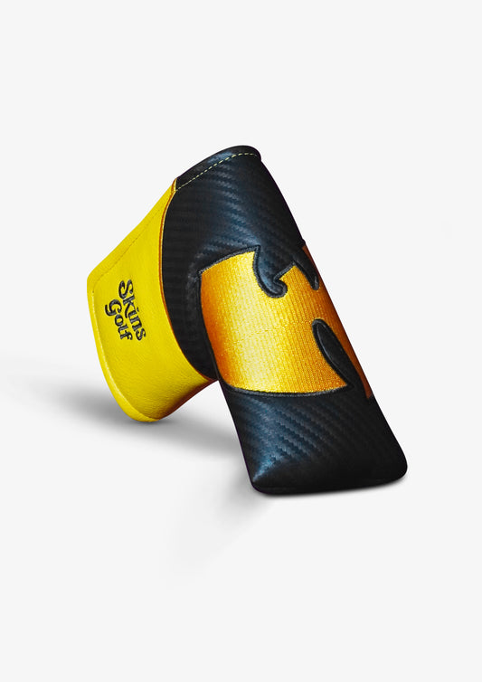 A golf club headcover in black and yellow, featuring a carbon fiber pattern on the black sections and a textured yellow design with a stylized logo, shown on a light gray background.