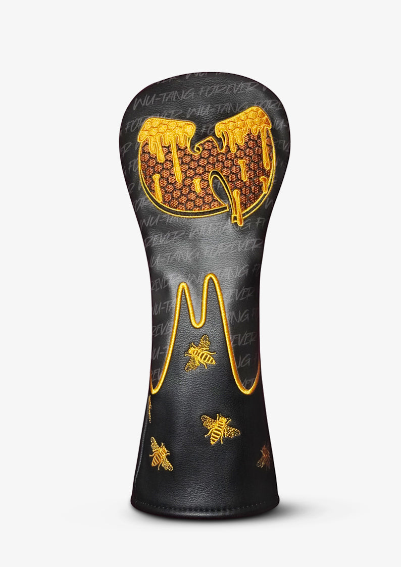 A black golf club headcover featuring a gold honeycomb and bee design, with a dripping honey graphic on the top, set against a light gray background.