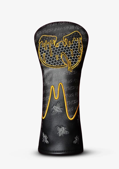 A black golf club headcover with a honeycomb pattern and gold and white embroidered details, shown on a light gray background.