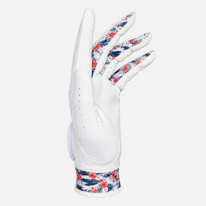 A white leather golf glove with a red and navy blue floral pattern on the back of the hand and wrist strap, shown against a light gray background.