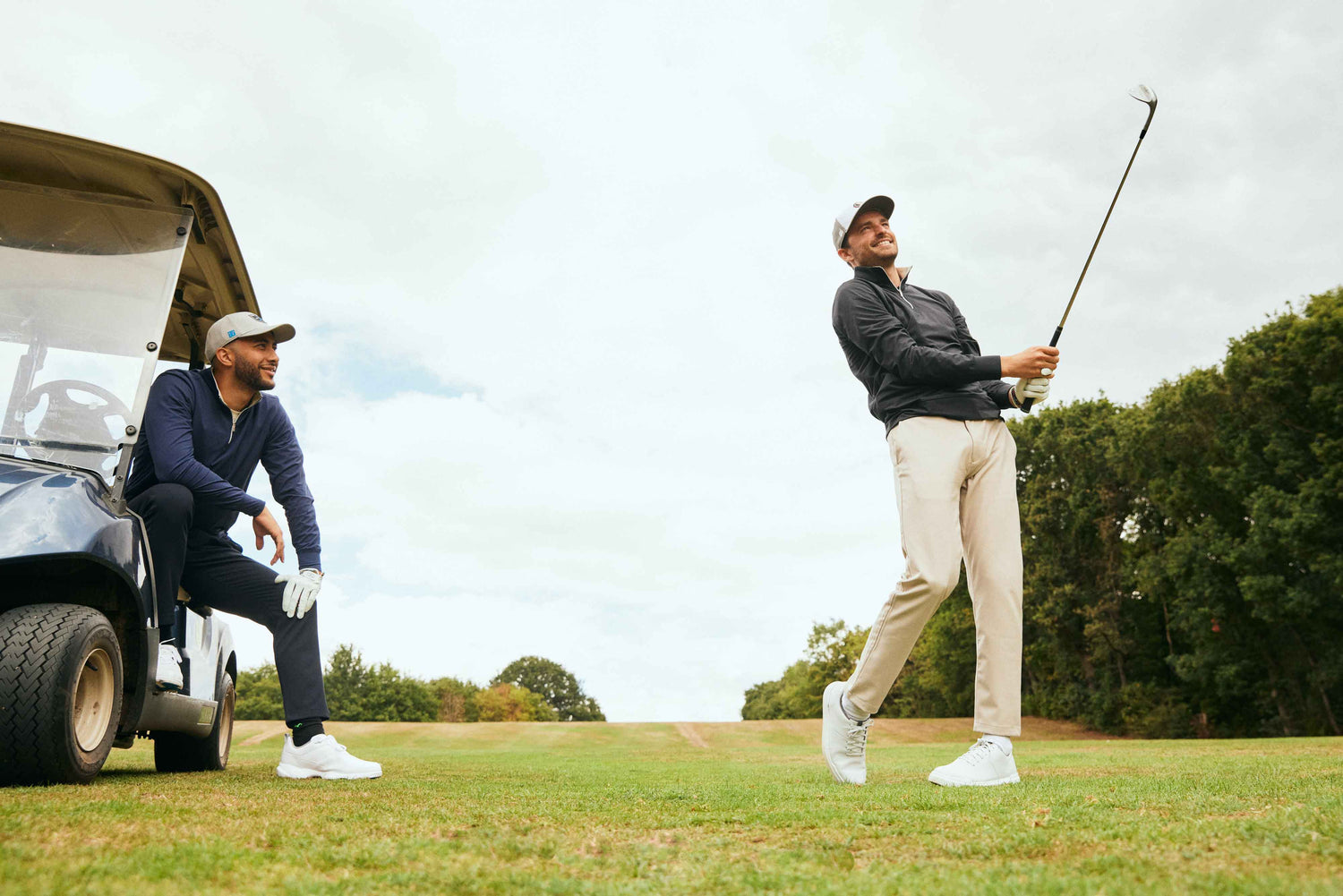 Golfers taking shot wearing golf clothes